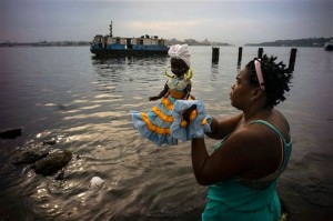 A follower of the Yoruba religion holding a doll depicting the goddess of Yoruba sea, before a procession in the holiday of the Virgin of Regla, Regla, a town across the bay from Havana, Cuba. (Ramon Espinosa AP Photo) 