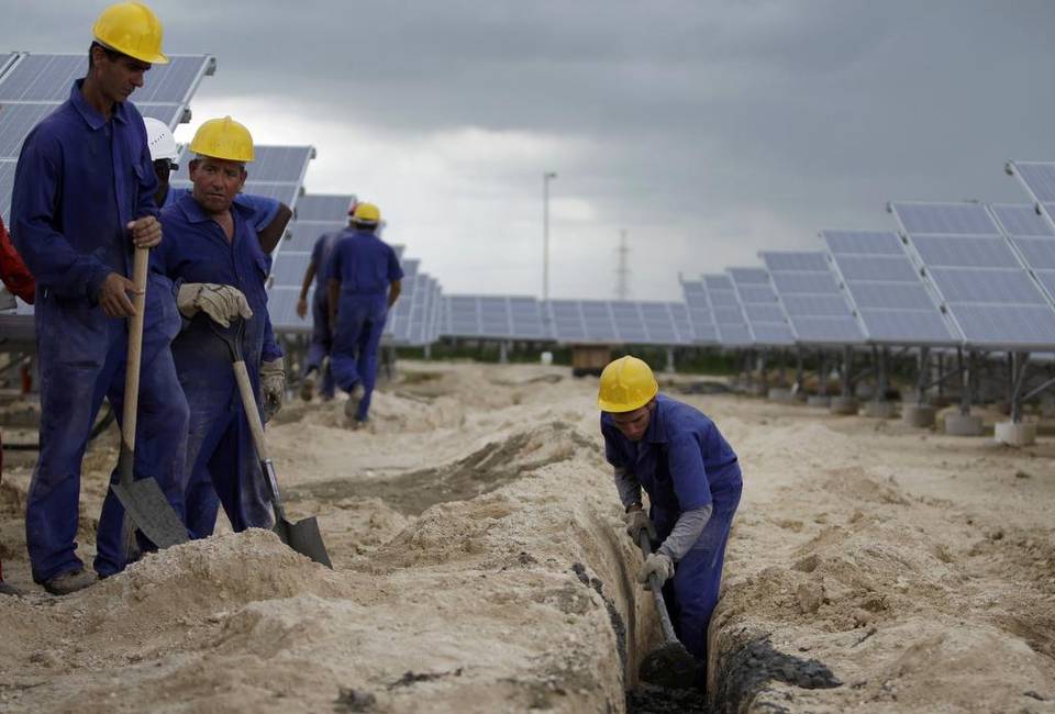 Trabajadores instalan una línea de alto voltaje que llevará la electricidad generada por paneles solares en la primera instalación de su tipo en Cantarrana, Cienfuegos. Franklin Reyes AP