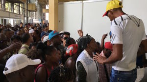 A man tries to contain the crowd that wants to go to the fair of Havana. (14ymedio)