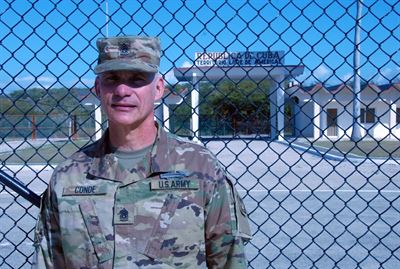 Command Sgt. Maj. Rafael Conde, the Wisconsin Army National Guard’s senior enlisted leader, stands by the northeast gate at Naval Station Guantanamo Bay, Cuba, Dec. 30, 2016. Conde was born in Cuba and fled to the United States as a child with his family. He returned to Cuba as part of an official visit led by Wisconsin Gov. Scott Walker and Maj. Gen. Don Dunbar, Wisconsin’s adjutant general, to visit with members of the Wisconsin Army National Guard’s 32nd Military Police Company deployed to Guantanamo Bay. Wisconsin National Guard photo.