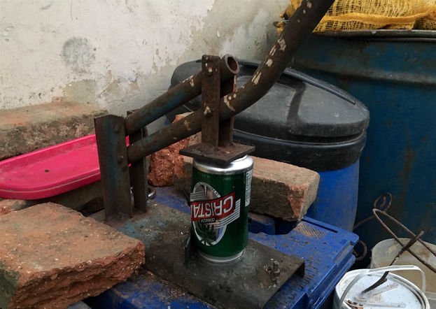 En el patio de su casa ha creado una herramienta para escachar las latas que recoge por las calles. (14ymedio)