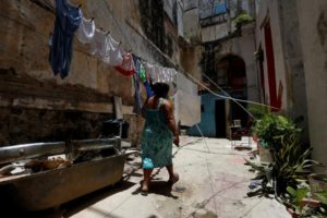 A woman walks on a patio and past drying laundry at a building, in Havana, Cuba May 28, 2017. Picture taken May 28, 2017. REUTERS/Stringer