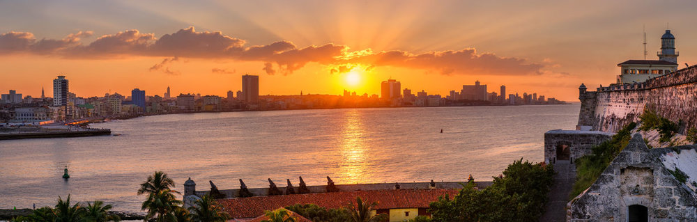 Sunset in Havana with the sun setting over the buildings and el