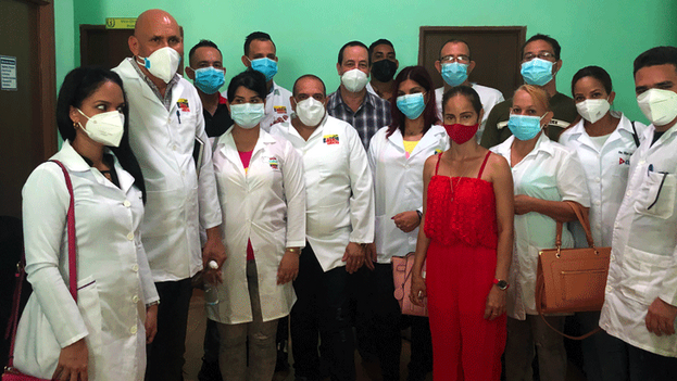 El ministro de Salud, José Ángel Portal Miranda, en el centro, con una veintena de médicos cubanos recién llegados de Venezuela. (PCC)