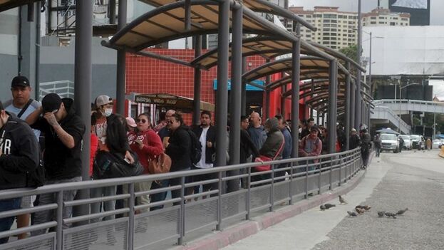 Fotografía de archivo de personas haciendo fila intentando cruzar hacia Estados Unidos en la frontera con México, en la ciudad de Tijuana en Baja California, (México). (EFE/Joebeth Terriquez)